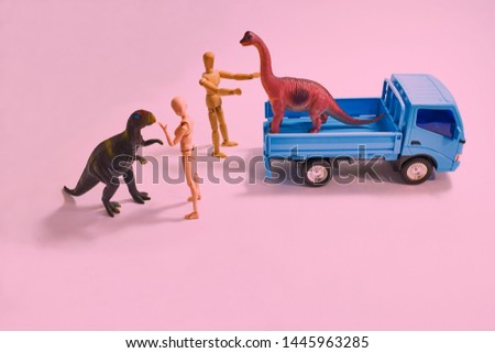   A scene from above looking down on a dinosaur model from a truck for an outdoor performance.                             