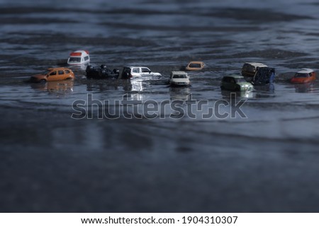 Scene of cars (miniature, toy model ) in flood from natural disasters,heavy rain, typhoon, hurricane.Transportation,Car insurance concept background.