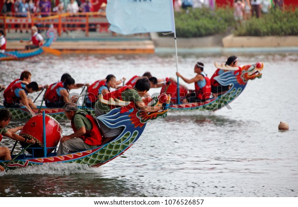 Scene of a competitive boat racing in the Dragon\
Boat Festival in Taipei, Taiwan, where the athletes pull vigorously\
on the oars & compete with all their strength in traditional\
colorful dragon boats