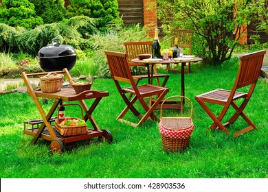 Scene Of Family Barbecue Grill Party Or Picnic On The Lawn In The Backyard At Summertime Weekend.