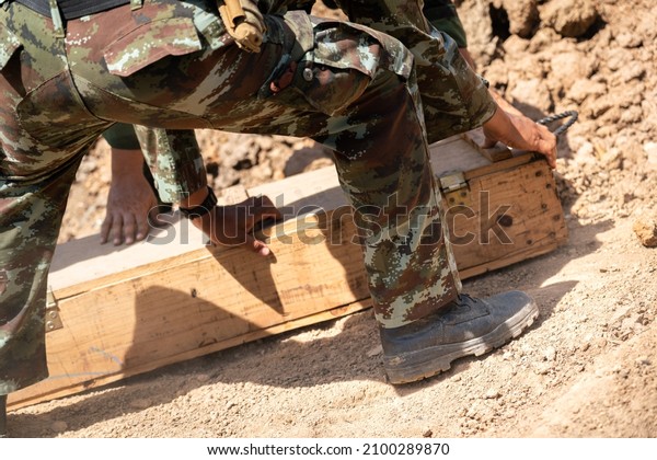 A scene of infantryman or soldier commander is\
standing on the dust ground with blurred of vehicle part as\
background, in the war battlefield. Close-up and selective focus at\
the combat shoe part.