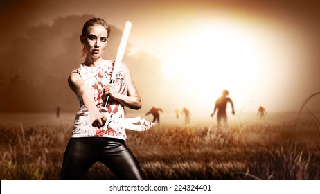 scene like in a horror movie with a woman holding a machete and a knife and standing on a field with approaching zombies 