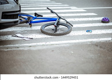 Scene of a road accident with car and broken bicycle lying on the pedestrian crossing