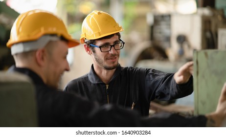 Scene shot of 2 industrial workers discussing about planning, the procedure of work in the factory with selective focus, concept industrial workers process, manufacturing operation.