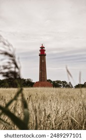 A scene of a small lighthouse standing alone in a grassy field