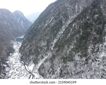 A  Scene Of Snowy Road Between Range Of Rocky Mountains Against A Light Blue Sky Rogers Pass, Canada