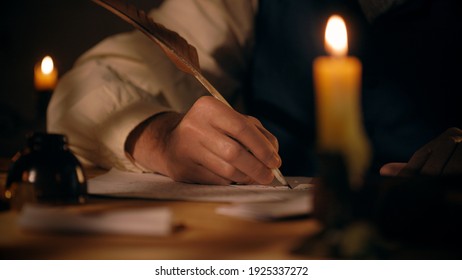 A scene typical of 18th century with soft focus on items on desk in foreground and main focus on man writing with quill pen in background. - Powered by Shutterstock