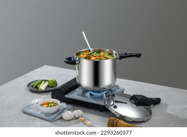 The scene of using a pressure cooker to make soup and cook dishes in the kitchen, marble countertop background, wood grain desktop.