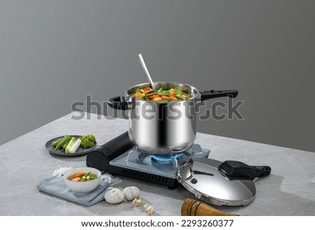 The scene of using a pressure cooker to make soup and cook dishes in the kitchen, marble countertop background, wood grain desktop.