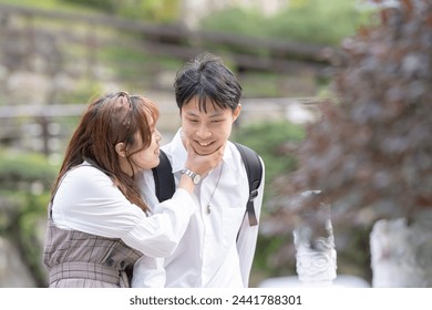 The scene of a young Taiwanese male and female couple in their 20s talking happily in the cat sky, a tourist destination in Taiwan 20代の若い台湾人の男女カップルが台湾の観光地である猫空で仲良く話す光景