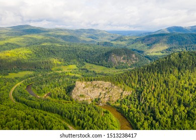 Scenery bird's eye view of winding Inzer river among green mountains in summer during sunny day