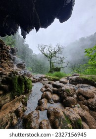 Scenery from a cliffside cave, undisturbed from human, with stalagmite and stalactite hanging from the ceiling
