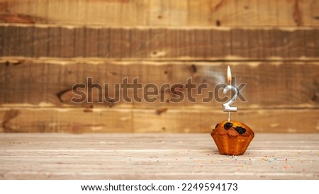 Scenery Festive wooden background happy birthday copy space. Anniversary background with number of burning candles and muffin. Beautiful brown from vintage boards background before a birthday  2