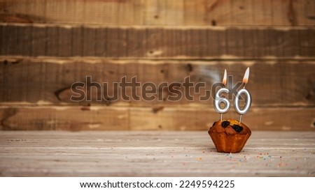 Scenery Festive wooden background happy birthday copy space. Anniversary background with number of burning candles and muffin. Beautiful brown from vintage boards background before a birthday  60