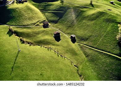 Scenic aerial panoramic view of idyllic rolling hills spring landscape in the Alps with lush green mountain pastures and wood houses - Powered by Shutterstock