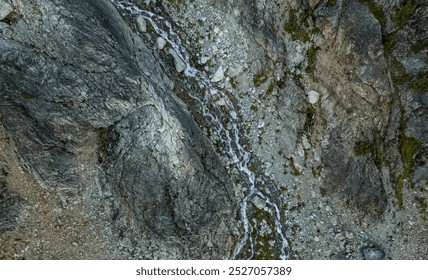 Scenic aerial view capturing the rugged mountain terrain with a flowing stream in British Columbia, Canada, showcasing natural beauty and geological formations. - Powered by Shutterstock