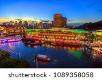 Scenic aerial view of Clarke Quay and Riverside area at blue hour in Singapore, Southeast Asia. Waterfront skyline reflected on Singapore River. Popular attraction for nightlife.
