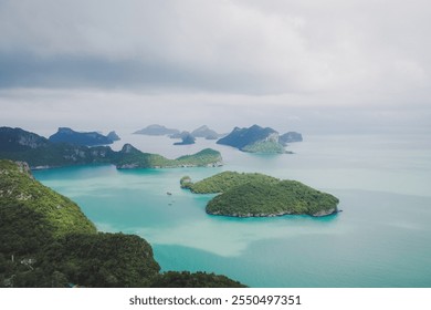 Scenic aerial view of tropical islands surrounded by turquoise waters, lush greenery, and a serene seascape under a cloudy sky. - Powered by Shutterstock