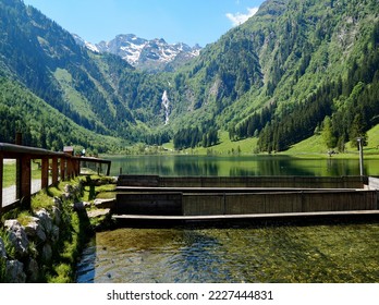 scenic alpine landscape with a waterfall, a transparent alpine lake and several trout breeding ponds in the Austrian Alps of the Schladming-Dachtein region in Styria or Steiermark in Austria