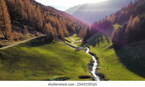 Scenic alpine valley with winding stream and autumn trees. - Powered by Shutterstock