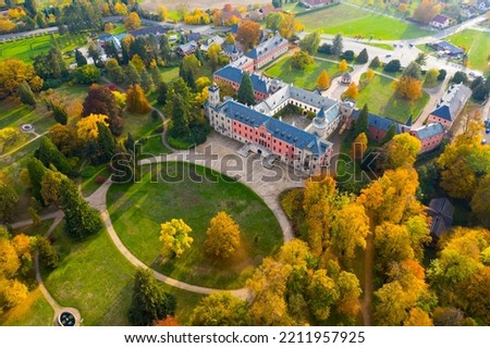 Scenic autumn landscape with large Castle complex near village of Sychrov with romantic neogothic building and English style park, Czech Republic..