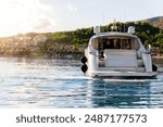 Scenic back view luxury private yacht boat sail at Croatian bay harbor shore blue turquoise clear water bright summer sunny sunset sunrise morning. Rich quality lifestyle. Boat vessel charter service