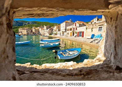 Scenic beach in Komiza waterfront view through stone window, Island of Vis, Croatia - Powered by Shutterstock