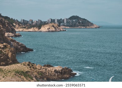 Scenic beach with rock formations and urban buildings in the distance in Fujian province in China. - Powered by Shutterstock