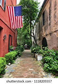 Scenic Brick Alleyway In Charleston, South Carolina With American Flags