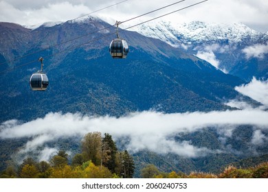 Scenic cable car flying over the colorful autumn mountains of Sochi, Russia. Beautiful scenery of fall foliage and majestic mountains