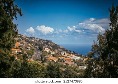 Scenic coastal hillside village overlooking the ocean under a bright blue sky. Lush greenery and red-roofed homes line a winding road, creating a peaceful, sunlit Mediterranean atmosphere. - Powered by Shutterstock