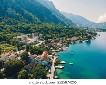 Scenic coastal view of waterfront village nestled against mountains in a serene setting during bright daylight hours - Powered by Shutterstock