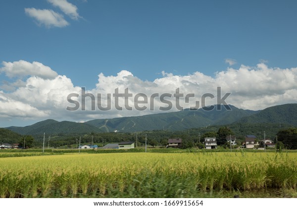 Scenic and epic\
landscape view from the road of Japanese Rice fields and mountains\
over the sky in Nagano.