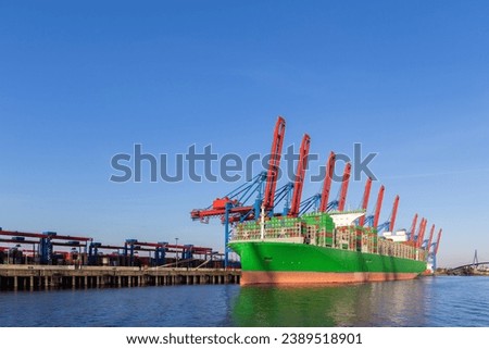 Scenic front giant cargo container ship loading Hamburg city port harbour seaport cranes on clear blue sky day background. Global commercial trade freight charter shipping logistics background