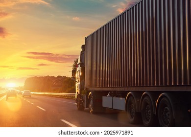 Scenic Front View Big Long Heavy Semi-treailer Truck With Sea Shipping Container Driving Highway Dramatic Warm Morning Evening Sunrise Sun Sky Sunset. Cargo Transport Industry Background Concept