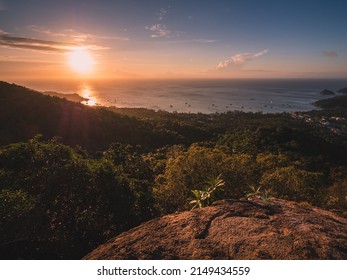 Scenic high angle view of sunset orange sky over the horizon and blue sea with sunbeam and Sairee beach in the peaceful evening. Shot from West Coast Viewpoint. Koh Tao Island, Surat Thani, Thailand.