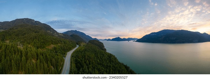 Scenic Highway on the ocean coast with mountain landscape. Sea to Sky Hwy, North of Vancouver, BC, Canada. Aerial view. Sunset