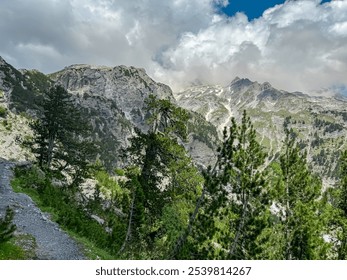 Scenic hiking trail surrounded by majestic steep mountain ridges of Albanian Alps (Accursed Mountains). Crossing high altitude pass between Valbone Valley and Thethi National Park, Albania. Wanderlust - Powered by Shutterstock