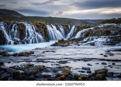 Scenic image of Iceland. Incredible nature landscape. Stunning view of Bruarfoss Waterfall. Azure water flows over stones. Bright midnight sun of Iceland. Iceland is a most popular place of travel.