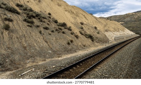 A scenic journey through BC's dramatic transition - from rushing glacial waters of Kicking Horse Canyon to the dry, rugged landscapes of the Thompson river near Kamloops where rail, river, and highway wind together through vast canyon terrain.