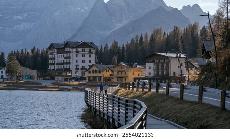 A scenic lakeside village in the Italian Alps is captured during autumn, perfect for travel inspiration and holiday relaxation Dolomite Alps, Dolomites - Powered by Shutterstock