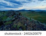 A scenic landscape featuring green hills and a cloudy sky. Colton Crater, Arizona
