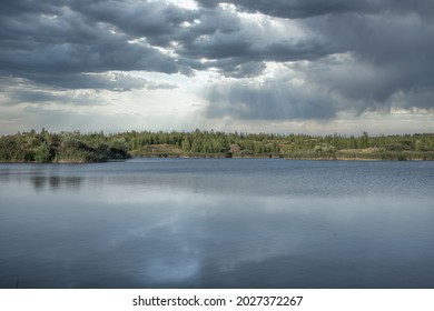 Paisaje escénico en el lago con un cielo dramático y fuertes nubes de lluvia  Árboles en el fondo  rayas de luz provienen de las nubes  Destinos escénicos  paisajes acuáticos  viajes  relajación 