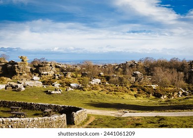 Scenic landscape with rocky formations, greenery, and a clear sky, ideal for travel and nature themes at Brimham Rocks, in North Yorkshire