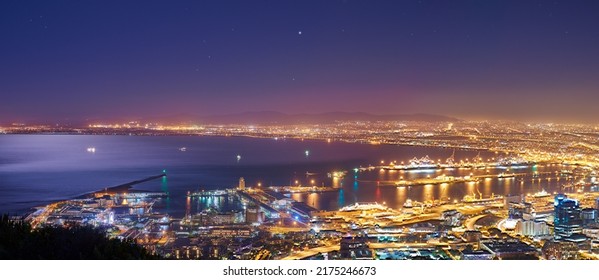 Scenic landscape view of Cape Town city and harbour lit at night after sunset from Signal Hill, South Africa. Electricity and electrical lights burning in evening with clear blue sky and copy space - Shutterstock ID 2175246673
