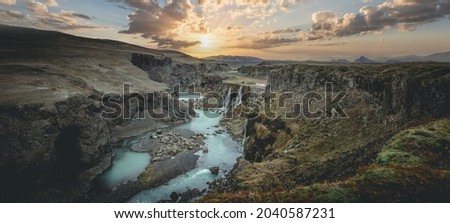 Scenic landscape view of incredible Sigoldugljufur canyon in highlands with turquoise river and sunset, Iceland. Volcanic landscape on background. Popular tourist attraction.