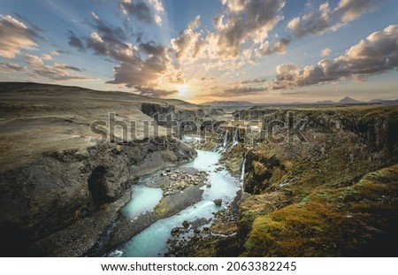 Scenic landscape view of incredible Sigoldugljufur canyon in highlands with turquoise river and sunset, Iceland. Volcanic landscape on background. Popular tourist attraction.