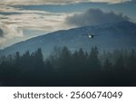 Scenic Light Aircraft Landing Over Misty Forest and Mountain Landscape. Cessna 172 single engine aircraft