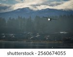 Scenic Light Aircraft Landing Over Misty Forest and Mountain Landscape. Cessna 172 single engine aircraft