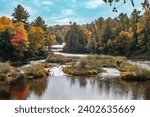 The scenic lower falls of Tahquamenon Falls state park in Michigan surrounded by autumn foliage